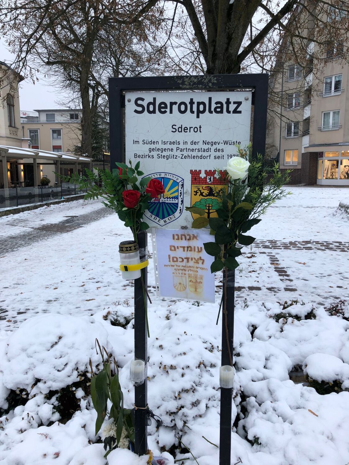 Dezember 2023: Blumen und Kerzen auf dem Sderotplatz unter einer Schneedecke