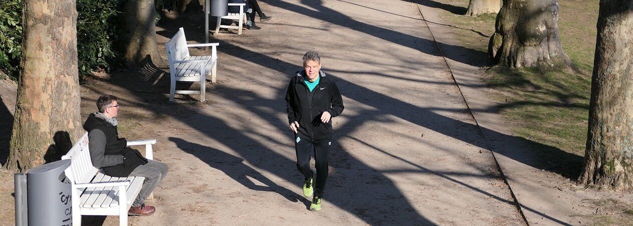 ein Mann joggt durch einen Park