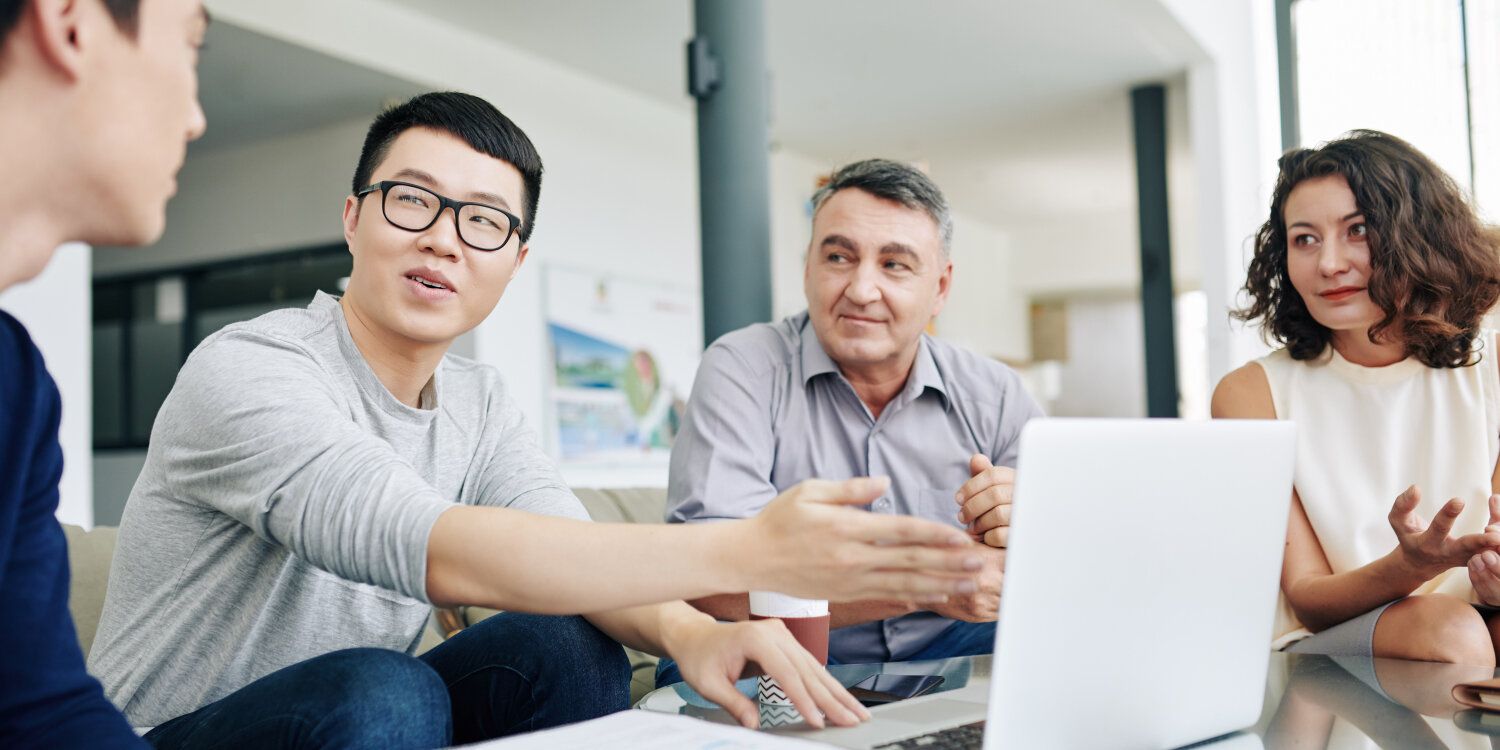Group of people in front of a laptop