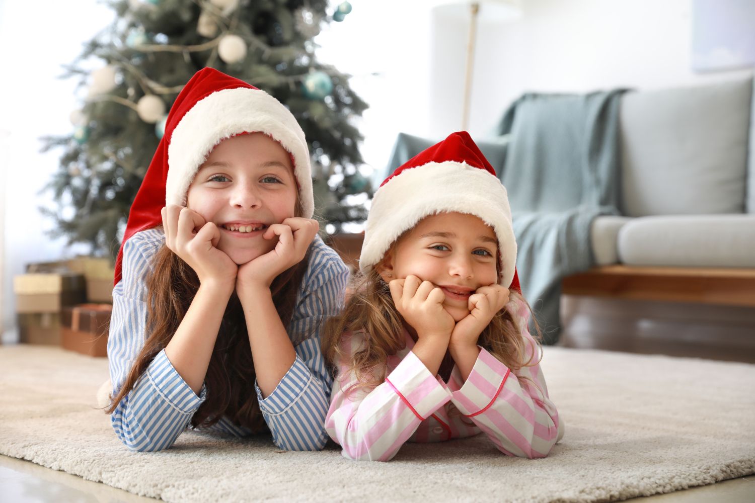 zwei Kinder vor dem Weihnachtsbaum