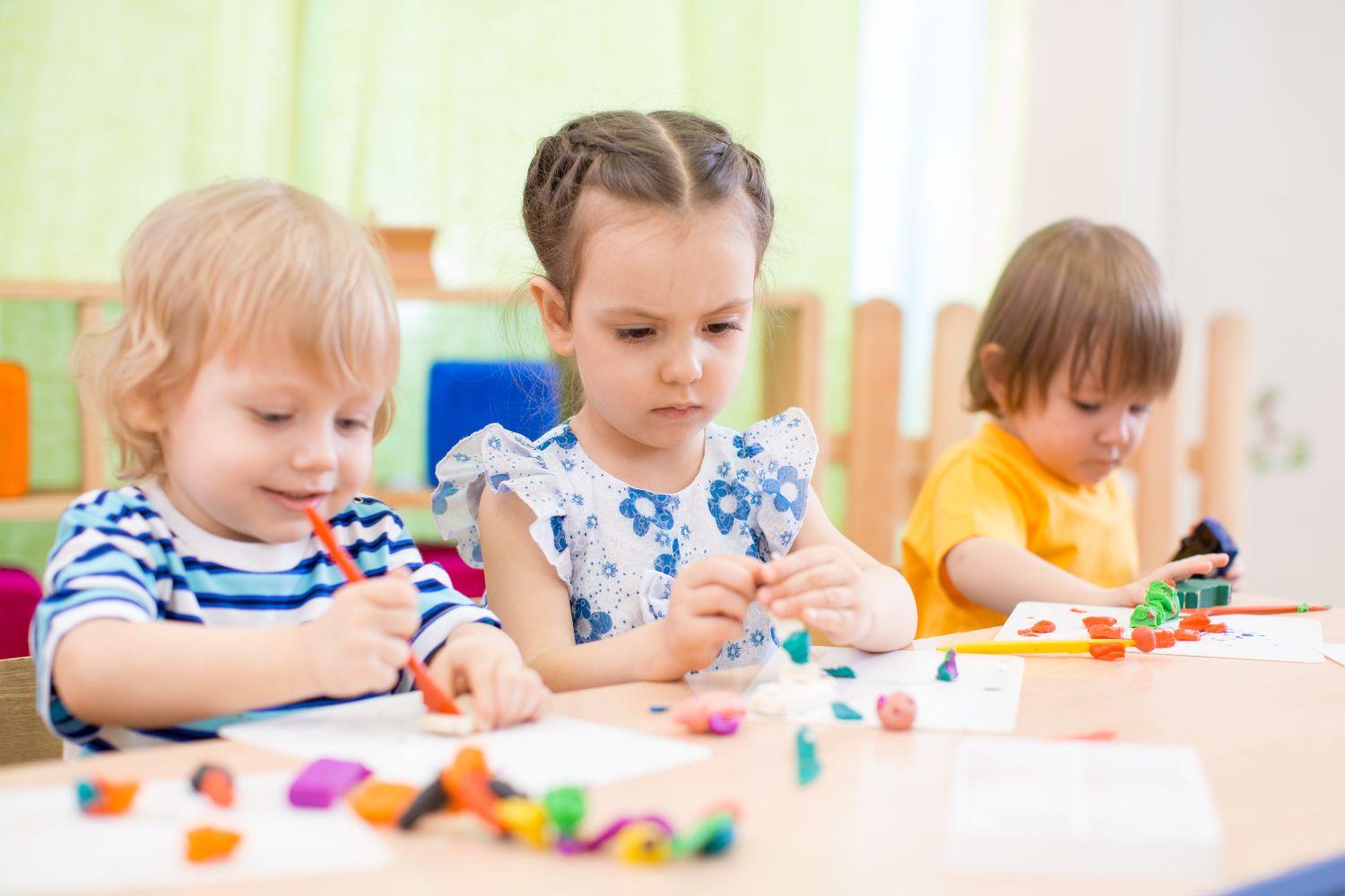 Drei Kinder basteln in der Kita