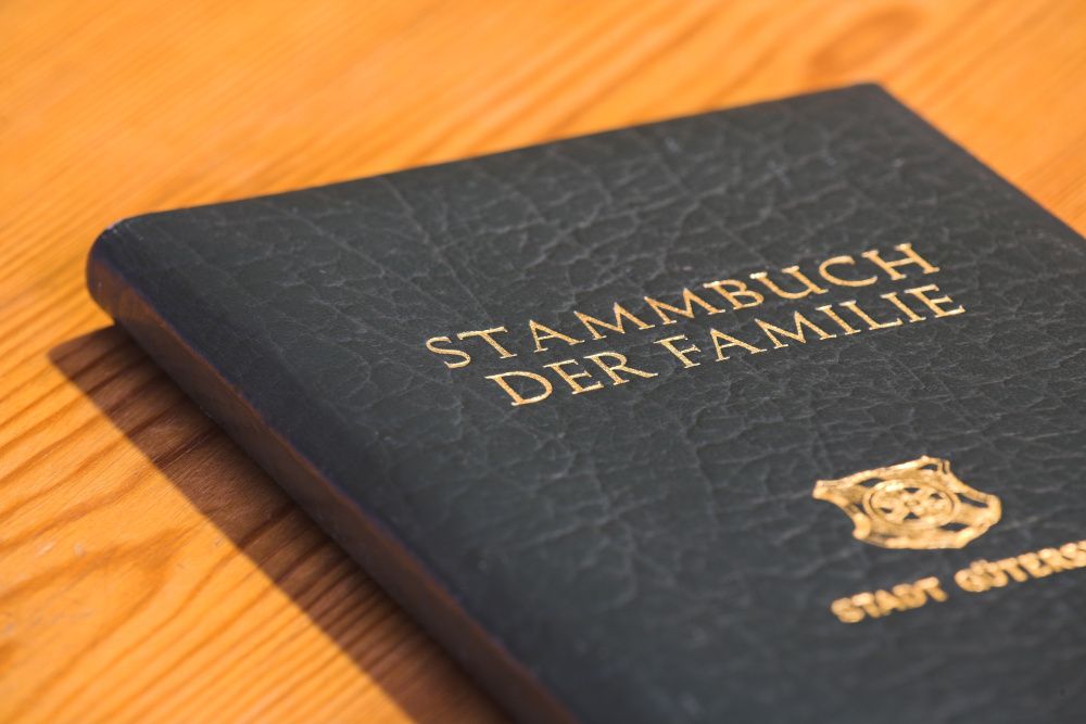 Ein Stammbuch aus schwarzem Leder liegt auf einem Holztisch