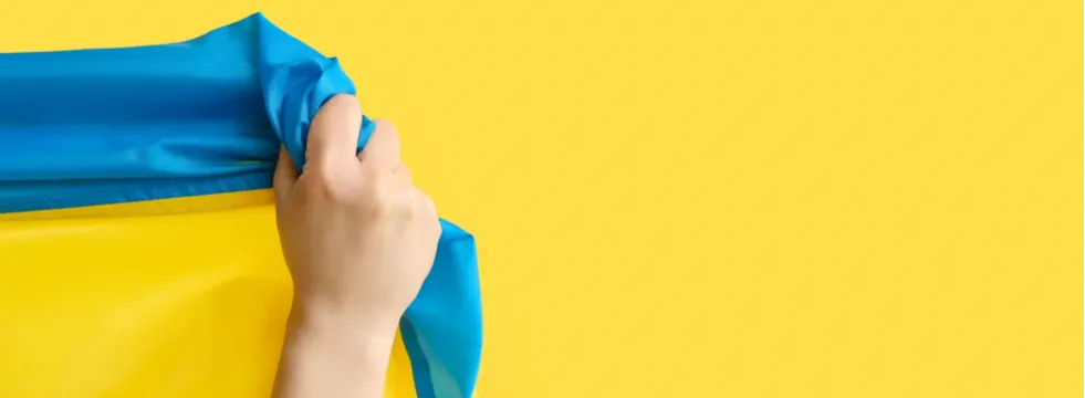 eine Hand hält eine Ukraine Flagge