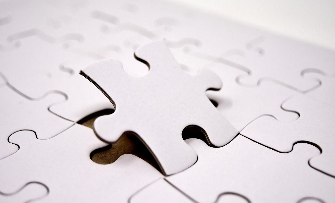 Weißes Puzzle, ein Puzzleteil leicht angehoben