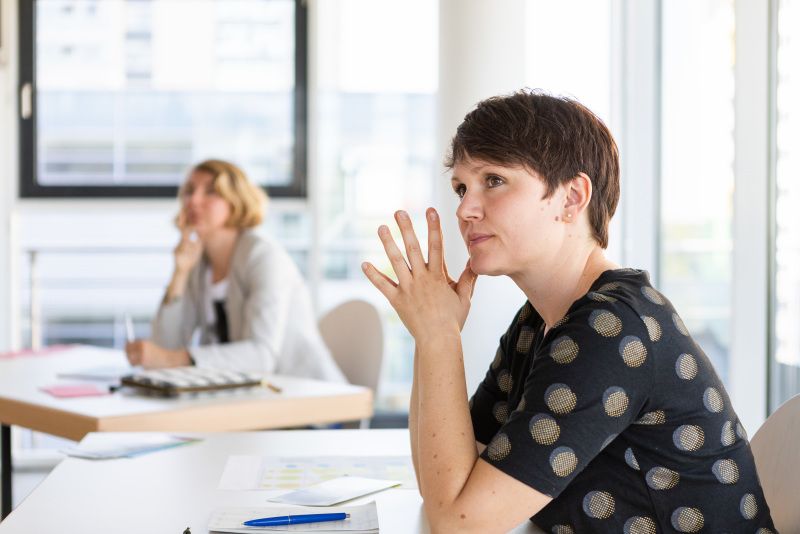 Lehrkraft hört in Seminar zu