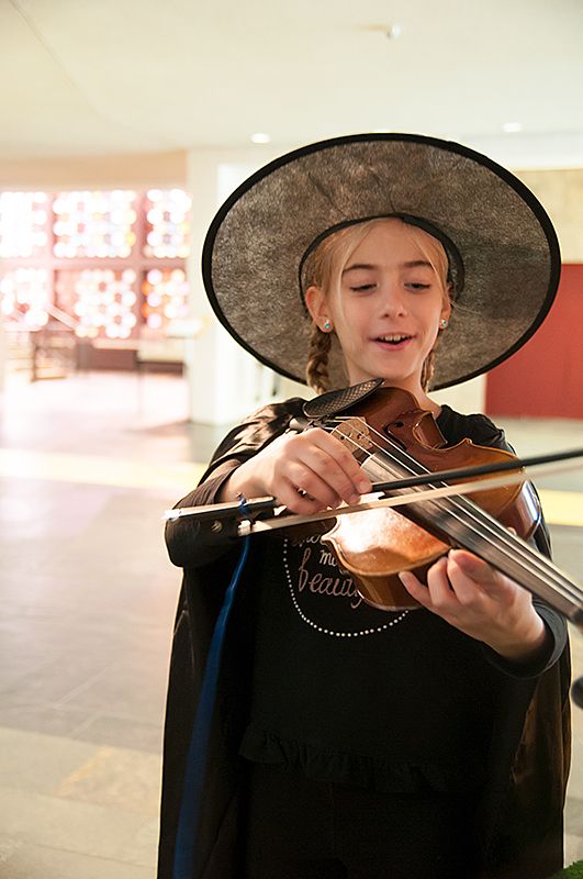 Ein Kind im Zauberumhang an der Violine