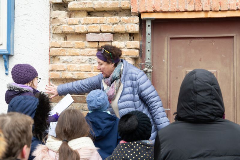 Kindergruppe bekommt von einer Frau etwas erklärt