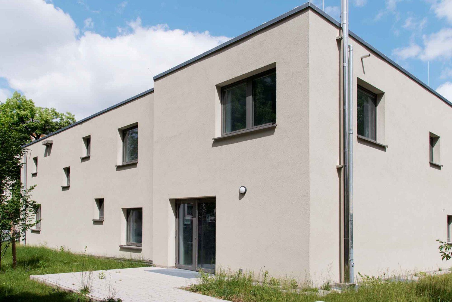 Blick von Westen: Die neue Fassade des Altbaus wird durch zusätzliche Fenster aufgelockert.