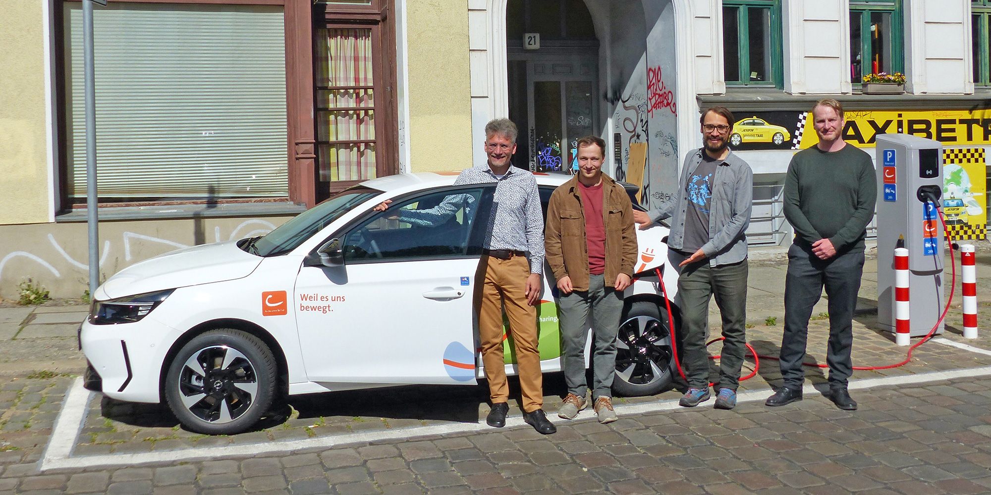Neu errichtetete stationsbasierte Ladeeinrichtung mit E-Carsharingfahrzeug sowie Vertretern des Unternehmens Cambio, des Bezirks Friedrichshain-Kreuzberg und der SenMVKU