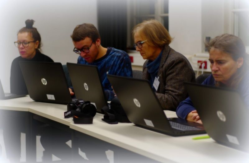 4 Personen an Laptops
