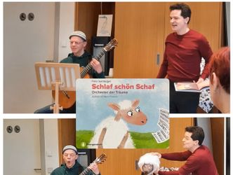 Ein Mann spielt Gitarre daneben aggiert ein Man mit einem Schaf in der Hand
