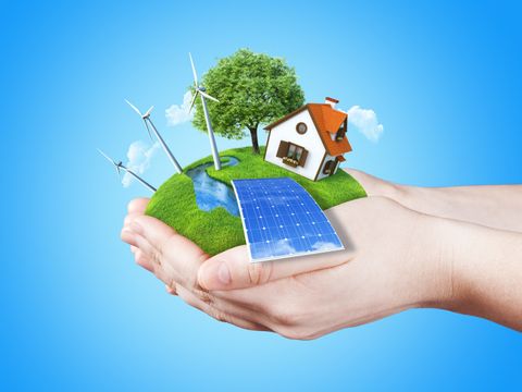  Die Hände halten klar grüne Wiese mit Batterie, Solarmodul, Mühle, Windkraftanlagen und Haus. Konzept für Ökologie, alternative Energie, frische, Freiheit. grün 
