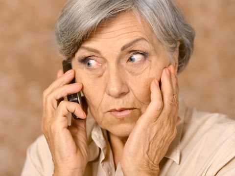 Ältere Frau mit Handy zuhörend