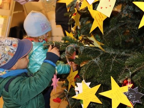 Kinder aus Pflege- und Betreuungseinrichtungen haben ihre Weihnachtswünswche in Sternform gebastelt und hängen diese jetzt an denNeuköllner Wunschbaum im Rathaus.
