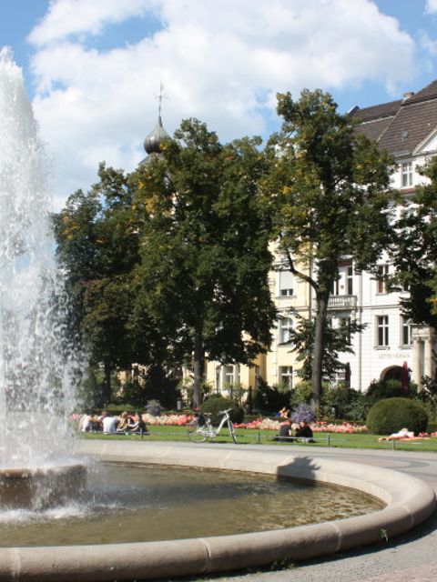 Belebter Viktoria-Luise-Platz in Schöneberg mit Springbrunnen