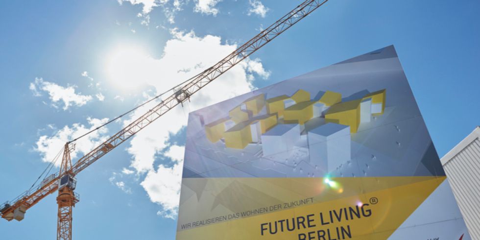 Ein Kran und ein Bauschild für Future Living Berlin