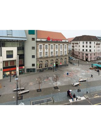 Bildvergrößerung: Pflaster am Alfred-Scholz-Platz mit unterschiedlich farbigen Gesteinssorten (Gneis, Granit etc.) aus acht verschiedenen Ländern der Welt. 