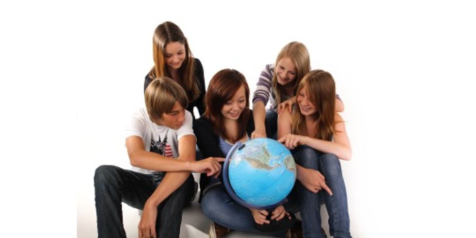 Jugendliche gucken auf einen Globus