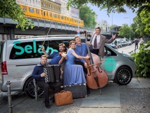 Bildvergrößerung: Hier sehen Sie fünf Musiker vor einem Van