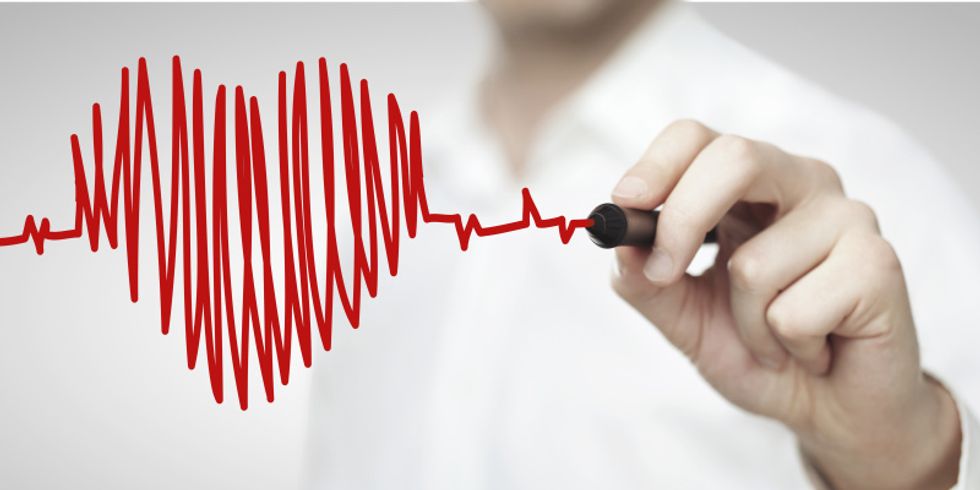 Mediziner malt ein Herz, das in ein EKG übergeht