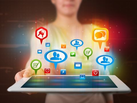Frau präsentiert ein Tablet mit bunten Social Media Symbolen