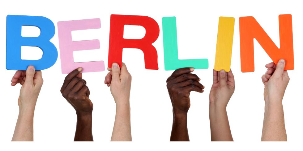 Hände von multikultureller Menschen-Gruppe halten die Buchstaben für das Wort Berlin hoch