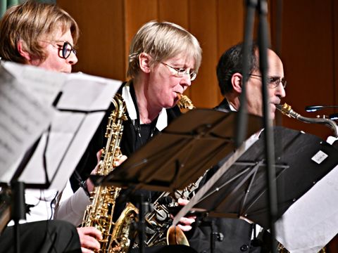Zwei Frauen und ein Mann spielen Saxophon 