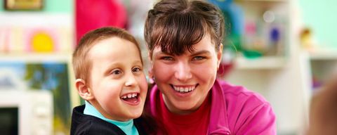 Lächelnder Junge und lächelndes Mädchen mit geistiger Behinderung in einer Rehabilitationseinrichtung