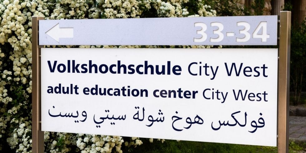 Schild VHS City West Eingang Prinzregentenstraße auf Deutsch, Englisch und Arabisch