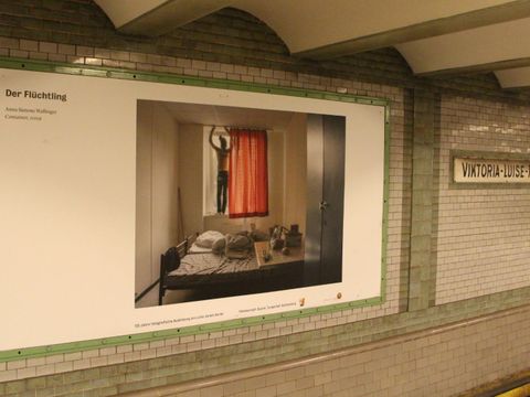 Bildvergrößerung: Auf der Wand des Bahnhofs Viktoria-Luise-Platz ist ein Bild von Anna Simone Wallinger.
