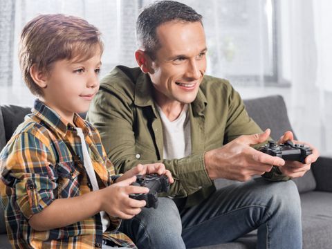 ein Mann und ein Kind spielen gemeinsam ein Computerspiel