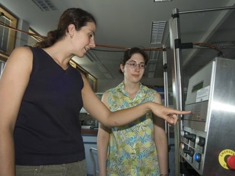 Eine Frau erklärt einer anderen Frau eine Maschine im Labr.