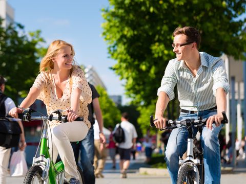 Paar in Stadt fährt mit Fahrrad in Freizeit