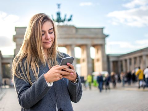 Frau mit Smartphone am Brandenburger Tor