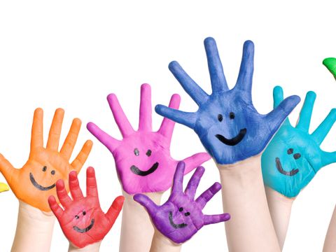 lachende Kinderhände in regenbogenfarben