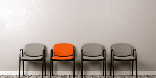 vier Stühle, wobei einer farblich hervor gehoben ist