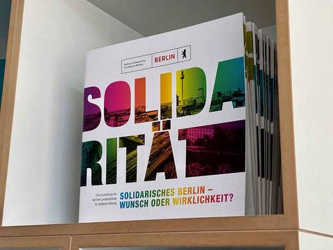 Broschüren zur Ausstellung "Solidarität" in einem Regal