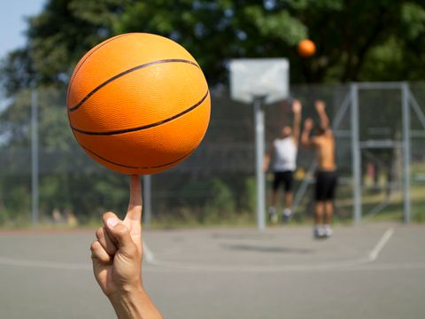Basketball im Vordergrund auf einem Finger drehen