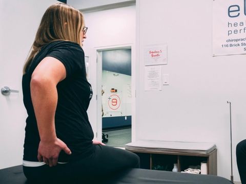 Eine Frau befindet sich in physiotherapeutischer Behandlung und schildert dem Physiotherapeuten ihre Schmerzen im unteren Rücken.
