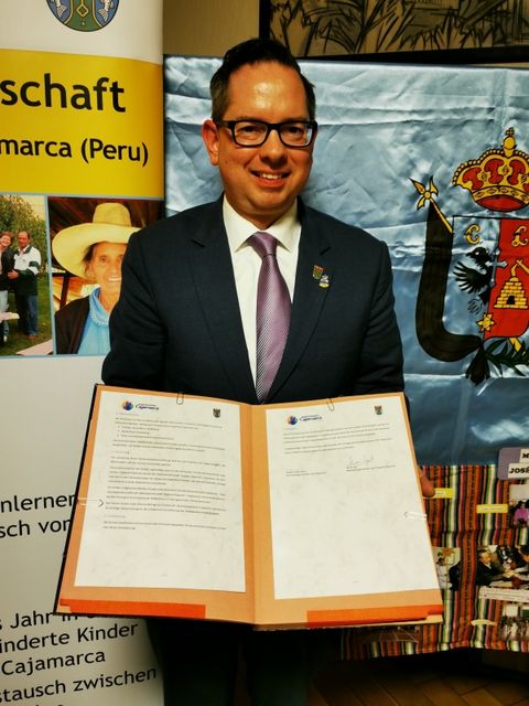 Bildvergrößerung: Bezirksbürgermeister Igel präsentiert die aktualisierte Städtpartnerschaftsvereinbarung