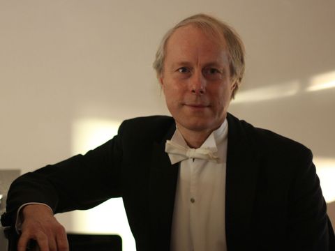 Das Farbfoto zeigt den Pianisten Kurt Wiklander am Klavier sitzend.
