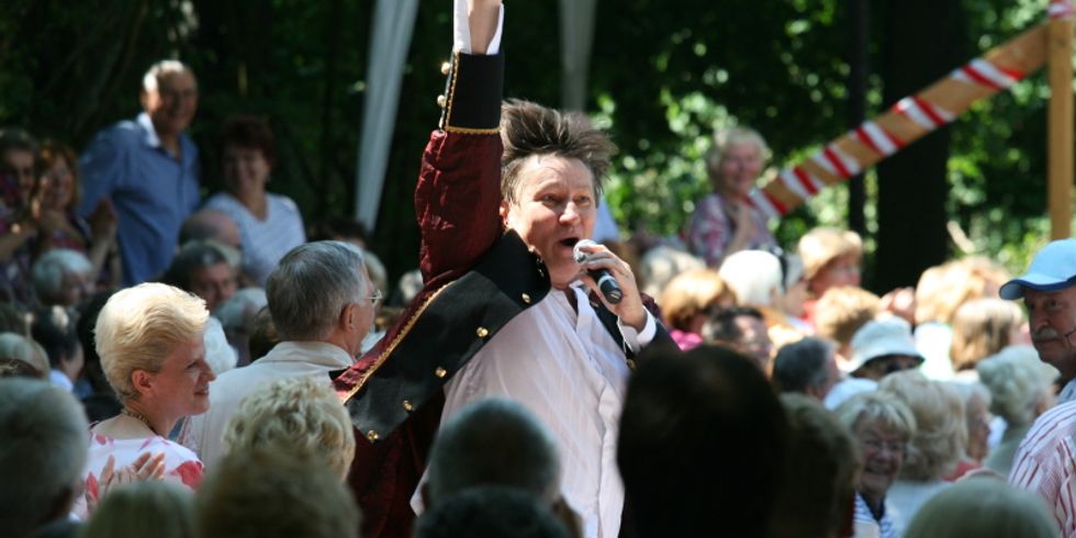 Musiker mit nach oben gestrecktem Arm beim Konzert im Garten der Alten Dorfschule Rudow