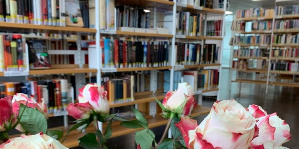 Strauß Rosen mit Bücherregalen im Hintergrund