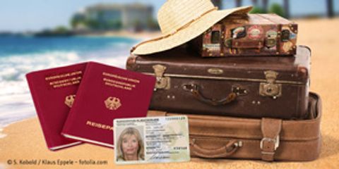 Stapel Koffer, im Vordergrund Reisepass und Personalausweis