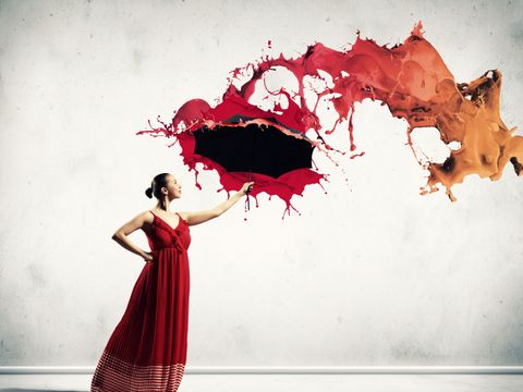 Ballettänzerin in rotem Kleid mit Schirm in der Hand