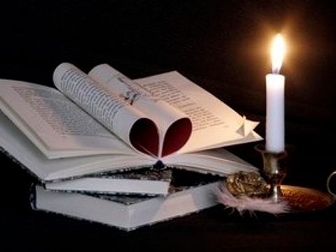 Aufgeschlagenes Buch mit Kerze