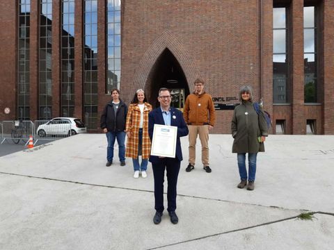 Bildvergrößerung: Bezirksbürgermeister Igel hält die Urkunde zur Titelerneuerung – Fairtrade Town Treptow-Köpenick in den Händen