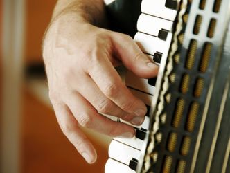 Hand eines Musikers spielt auf dem Akkordeon