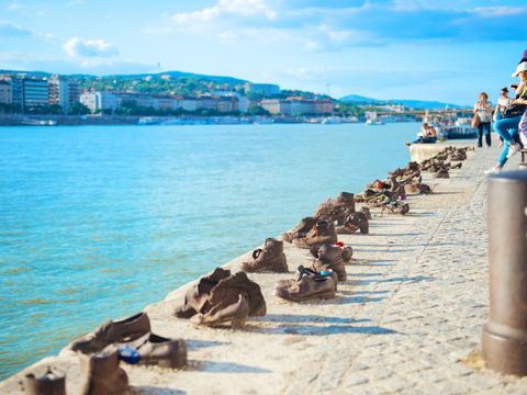 Touristen fotografieren Schuhe am Donauufer