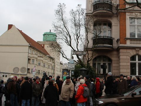 Bildvergrößerung: Versammelte Menschen am Straßenschild Sponholzstraße.